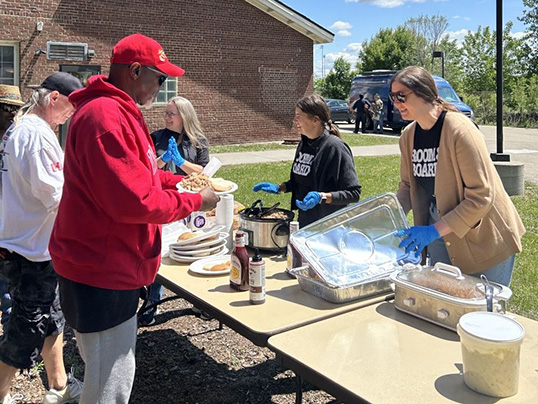 A group of veterans grab food during an outside BBQ.