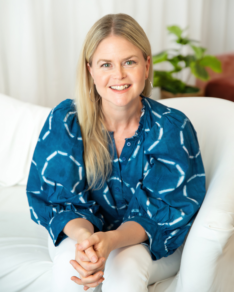 A headshot of Heather Ikemire, Executive Director for Lifetime Arts. She has long blonde hair and blue eyes. She is wearing a blue blouse.