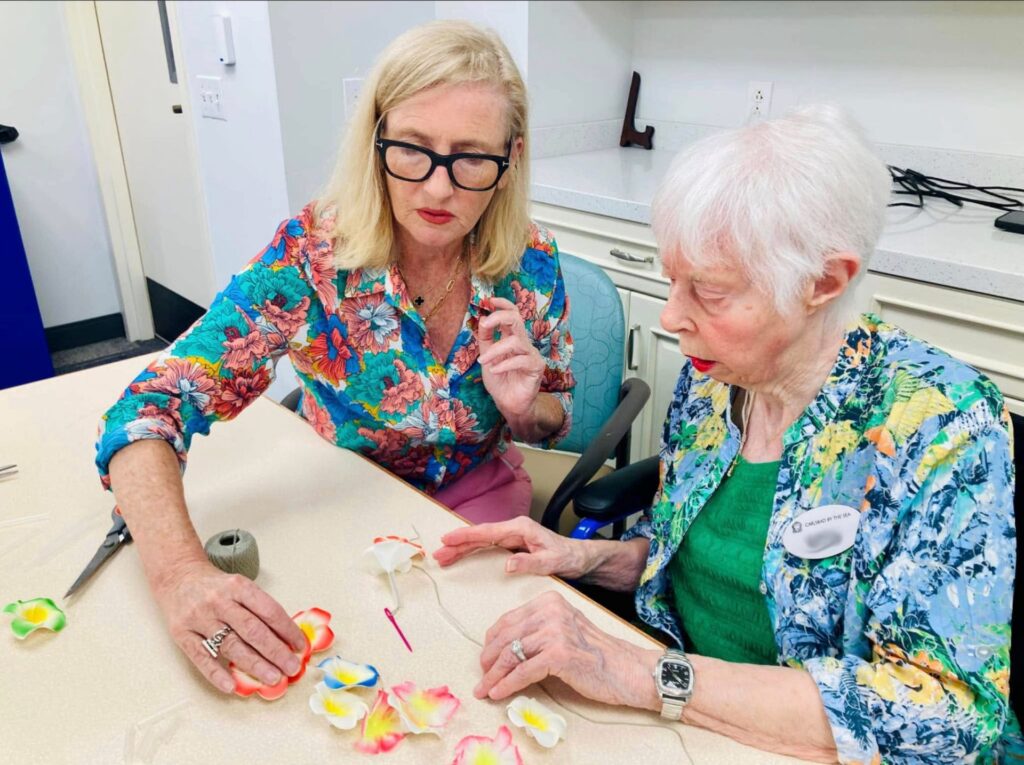 Jean Keane with an older adult making art together.