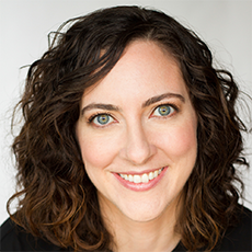 Headshot of Julie Kline. She has dark wavy hair and hazel eyes. She is smiling.