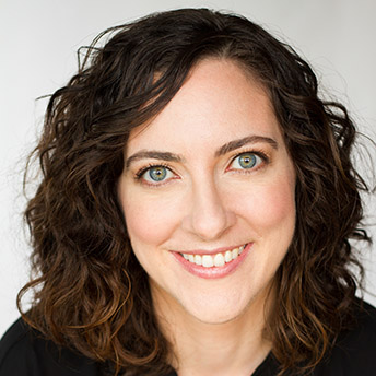 Headshot of Julie Kline. She has wavy shoulder-length brown hair and hazel eyes. She is smiling.
