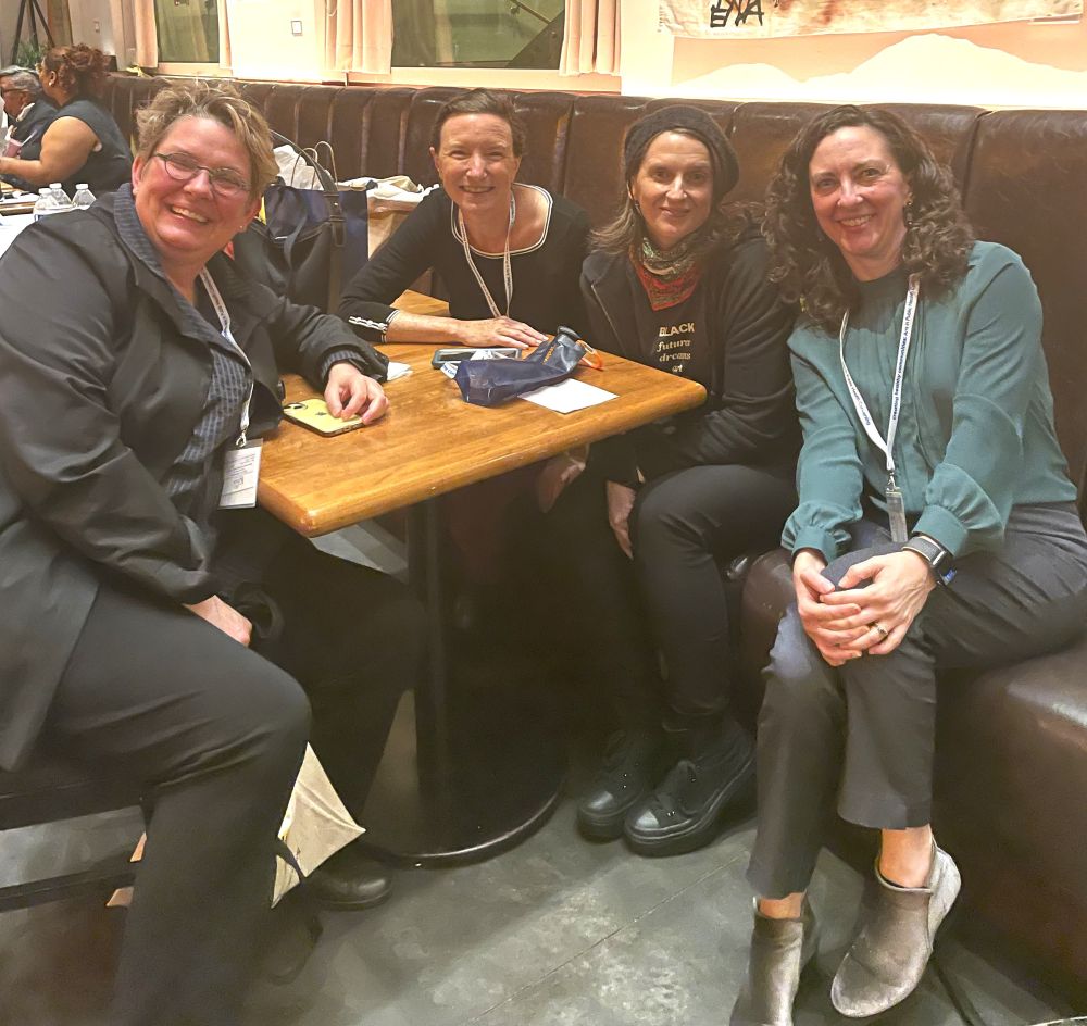 A group of arts and health leaders smile whiles it