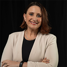 Headshot of Liza Cucco. She has short brown straight hair and light hazel eyes. She is smiling.