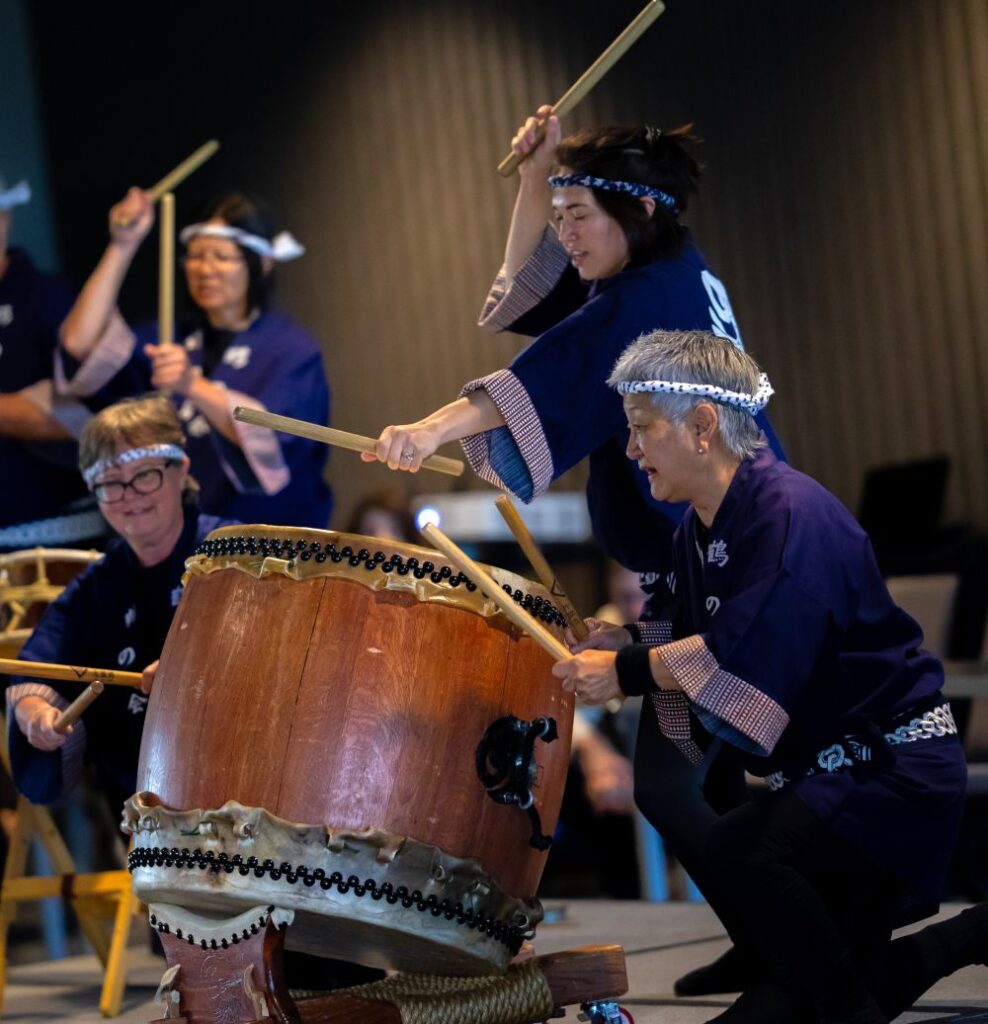 A group of intergenerational drummers perform.