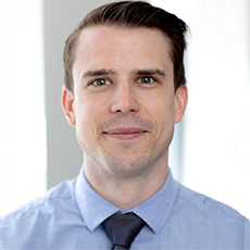 Headshot of Nathan Majoros. He has short dark brown hair and brown eyes. He is smiling.