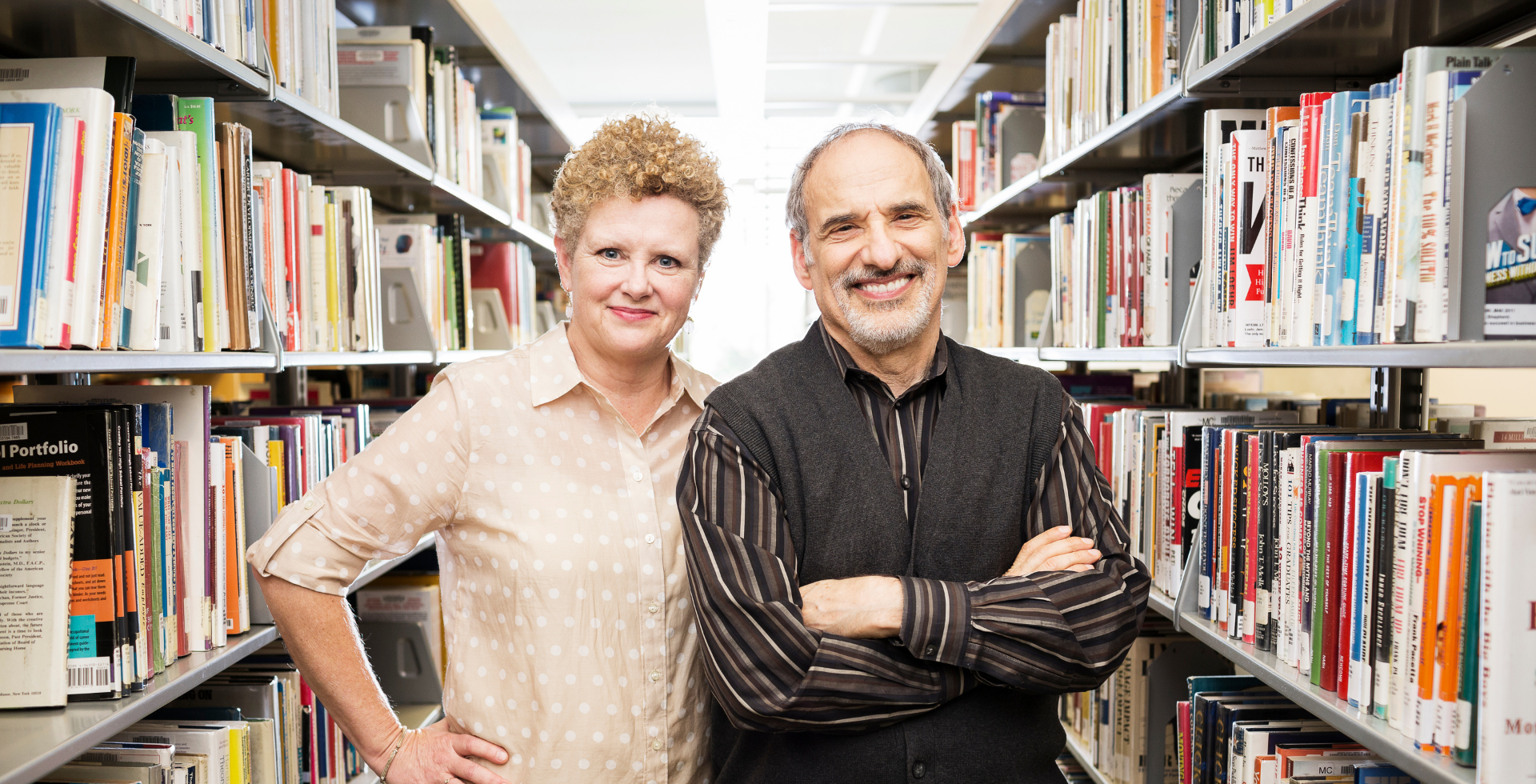 Posed photo of Maura O'Malley and Ed Friedman with bookshelves on both sides of them.