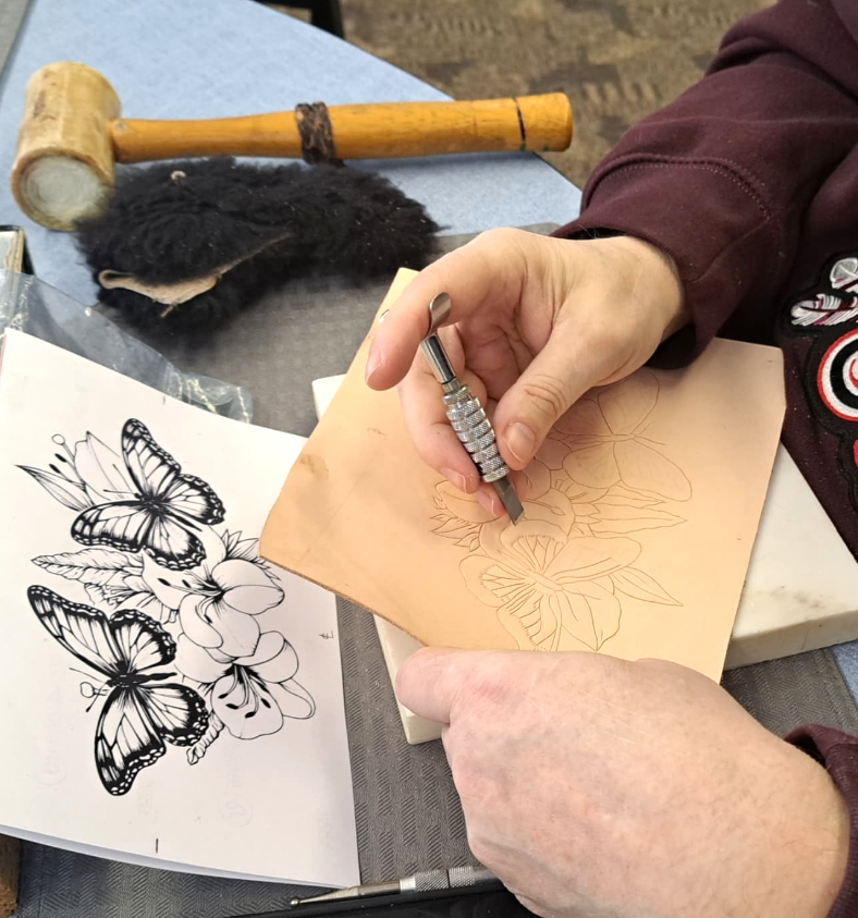 Close-up of an older adult working on leather-tooling during a program in Wyoming.