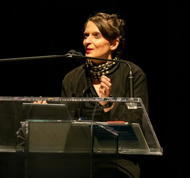 A photo of Dr. Tasha Golden speaking at a podium.